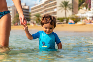 A mother with her son bathing, Ibiza beach on vacation at San Vicente beach, Balearic