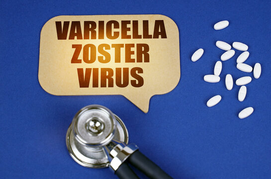 On the blue surface of the tablet, a stethoscope and a cardboard sign with the inscription - Varicella zoster virus