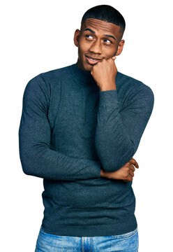 Young black man wearing casual sweater thinking concentrated about doubt with finger on chin and looking up wondering