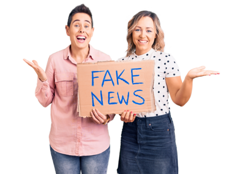 Couple of women holding fake news banner celebrating victory with happy smile and winner expression with raised hands