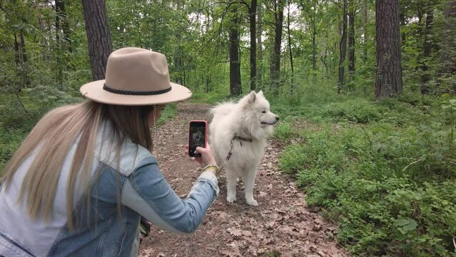 Woman take photo of her dog in the forest