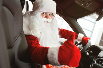 Santa sitting behind the wheel of a car shows a thumbs up - a class sign.