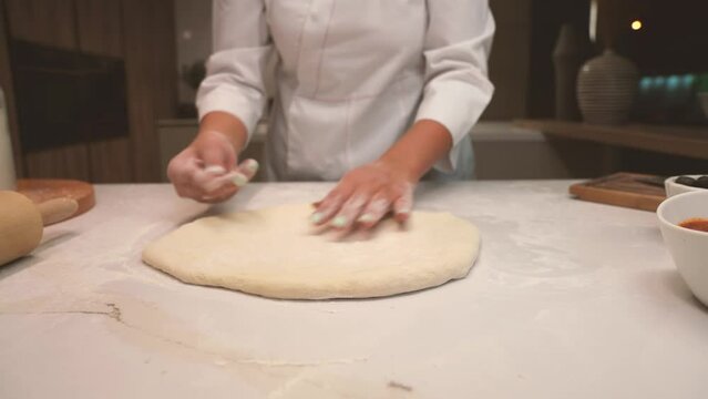 chef Kneading dough on a wooden table
