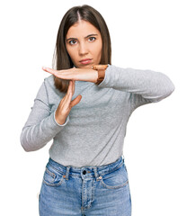 Young beautiful woman wearing casual turtleneck sweater doing time out gesture with hands,...