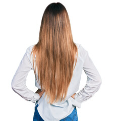 Beautiful caucasian woman wearing casual white shirt standing backwards looking away with arms on body