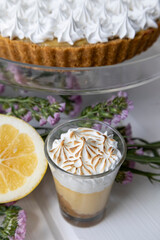 decoration of exquisite chocolate cake with pastry cream next to a cup with coffee and lemon, pastries and fruits in studio, kitchen