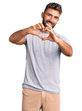 Young hispanic man wearing casual clothes smiling in love doing heart symbol shape with hands. romantic concept.