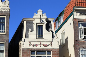 Fototapeta na wymiar Amsterdam Damrak Street Historic House Facade with Sculpted Festoon and Dormer Close Up, Netherlands