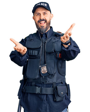 Young handsome man wearing police uniform smiling cheerful offering hands giving assistance and acceptance.