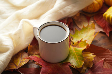 Two white cups with black coffee in a cozy autumn setting with red, yellow and orange leaves,...