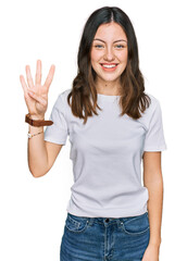 Young beautiful woman wearing casual white t shirt showing and pointing up with fingers number four while smiling confident and happy.
