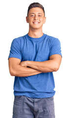 Young handsome hispanic man wearing casual clothes happy face smiling with crossed arms looking at...