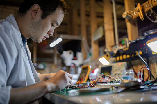 Male engineer assembling electronics in workshop