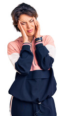Young beautiful woman wearing sportswear with hand on head, headache because stress. suffering migraine.