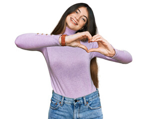 Young beautiful teen girl wearing turtleneck sweater smiling in love doing heart symbol shape with hands. romantic concept.