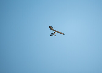 Powered paraglider flight. Hobbies and aviation sports. Paraglider against the blue sky.