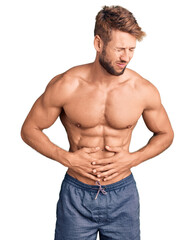 Fototapeta premium Young caucasian man standing shirtless with hand on stomach because indigestion, painful illness feeling unwell. ache concept.