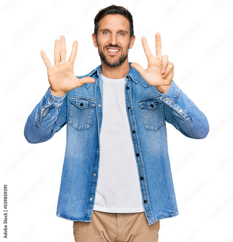 Sticker young handsome man wearing casual denim jacket showing and pointing up with fingers number eight whi