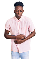 Young african american man wearing casual clothes with hand on stomach because indigestion, painful illness feeling unwell. ache concept.
