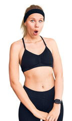 Fototapeta premium Young beautiful blonde woman wearing sportswear afraid and shocked with surprise expression, fear and excited face.