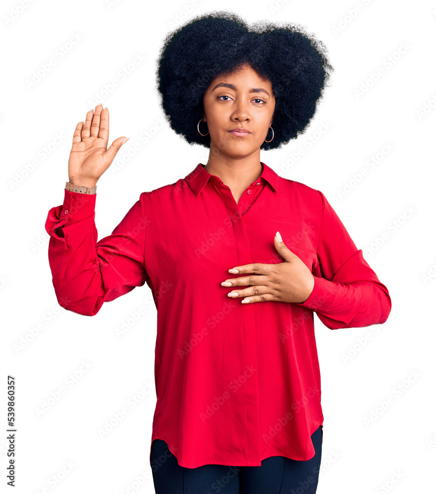 Wall mural Young african american girl wearing casual clothes swearing with hand on chest and open palm, making a loyalty promise oath