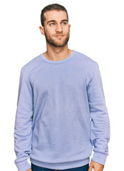 Fototapeta premium Young caucasian man wearing casual clothes smiling looking to the side and staring away thinking.