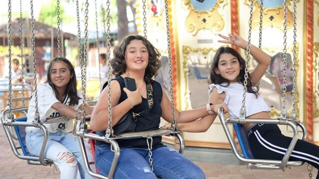 Three young girls on a ride on wave swinger