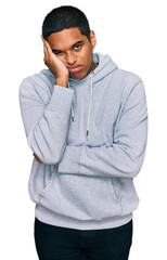 Young handsome hispanic man wearing casual sweatshirt thinking looking tired and bored with depression problems with crossed arms.