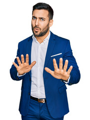 Young hispanic man wearing business jacket moving away hands palms showing refusal and denial with...