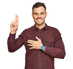 Young hispanic man wearing casual clothes smiling swearing with hand on chest and fingers up,...