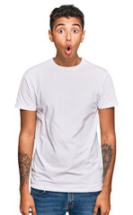 Young handsome african american man wearing casual white tshirt afraid and shocked with surprise expression, fear and excited face.