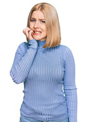 Young blonde woman wearing casual clothes looking stressed and nervous with hands on mouth biting nails. anxiety problem.