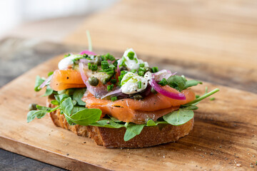 Open sandwich with smoked salmon, pickled onions, sour cream and capers