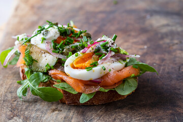 Open sandwich with smoked salmon, egg, pickled onions, sour cream and capers