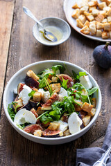 Fig and mozzarella salad with croutons and rocket leaves