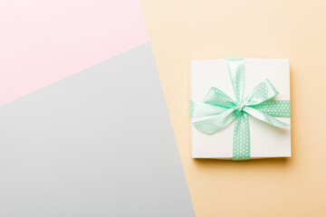 holiday handmade white present tied green ribbon bow top view with copy space. Flat lay holiday background. Birthday or christmas present. Christmas gift box concept with copy space