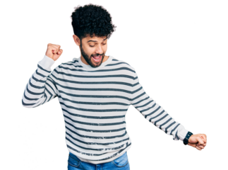 Young arab man with beard wearing casual striped sweater dancing happy and cheerful, smiling moving casual and confident listening to music