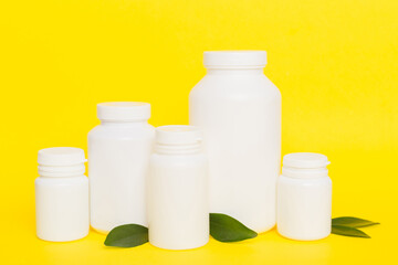 supplement pills with medicine bottle health care and medical top view. Vitamin tablets. Top view mockup bottle for pills and vitamins with green leaves, natural organic bio supplement, copy space