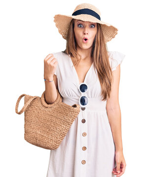 Young beautiful blonde woman wearing summer dress and wicker handbag scared and amazed with open mouth for surprise, disbelief face