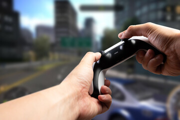 A gamer with a joystick in his hands against the background of a video game on a large TV screen plays an online game. Video games, modern dartless technologies, youth culture.