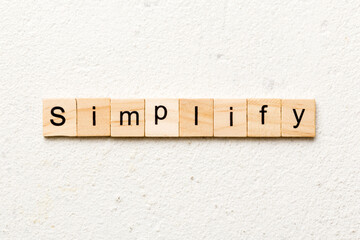 simplify word written on wood block. simplify text on table, concept