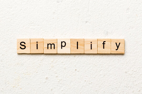 simplify word written on wood block. simplify text on table, concept