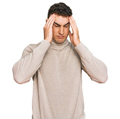 Naklejka premium Hispanic young man wearing casual turtleneck sweater suffering from headache desperate and stressed because pain and migraine. hands on head.