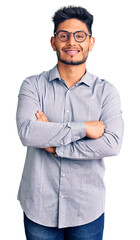 Handsome latin american young man wearing business clothes and glasses happy face smiling with crossed arms looking at the camera. positive person.
