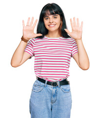 Young hispanic girl wearing casual clothes showing and pointing up with fingers number ten while smiling confident and happy.