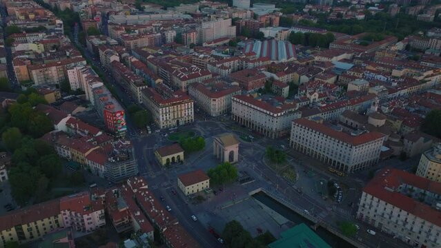 Aerial panoramic footage of town development in city at twilight. Piazza Ventiquattro Maggio square and Porta Ticinese gate. Milano, Italy