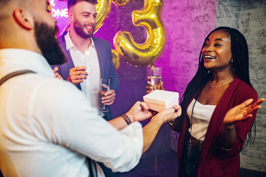 Multiracial couple exchanging gifts for birthday party or new years eve