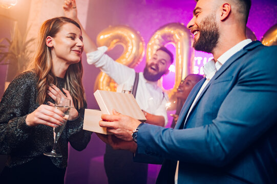 Couple exchanging gifts for birthday party or new years eve in the club