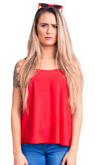 Fototapeta premium Young beautiful blonde woman wearing sleeveless t-shirt and sunglasses skeptic and nervous, frowning upset because of problem. negative person.