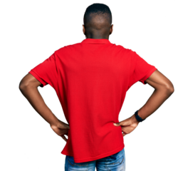 Young african american man wearing casual red t shirt standing backwards looking away with arms on body